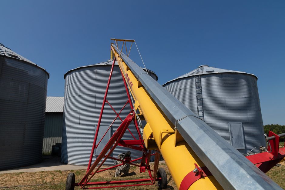 Auger set up between two grain bins on a farm